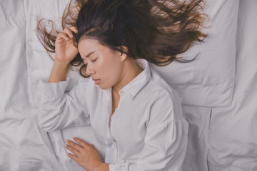 Young Woman Sleeping In Bed. Top view of young woman lying down sleeping well in bed. sleeping relax, young smiling pretty lady lies in bed. relaxing, sleeping.