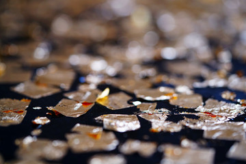 Shiny gild gold leaf and golden foil bokeh abstract background.