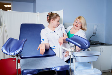 Fototapeta premium Experienced doctor fat woman teaching aspiring young doctor how to do peculiarities of medical work
