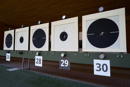 Bullseye target with bullet holes in center, close-up. Gun shooting range