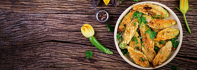 Fried zucchini flowers stuffed with ricotta and green herbs. Vegan food. Italian cuisine. Banner. Top view
