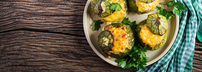 Zucchini stuffed with minced meat, cheese and green herbs. Baked in oven. Banner. Top view
