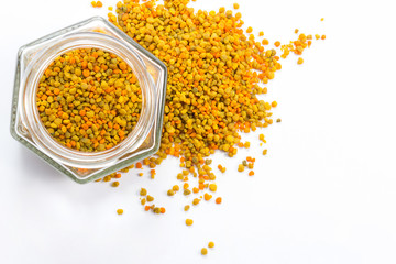Hexagonal jar with bee pollen on white background