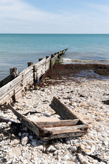 Fototapeta na wymiar wreck of a small wood boat on the beach in cap ferret Arcachon beach in France
