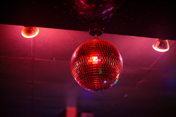 Disco ball in club lighting up the room