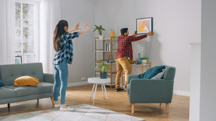 Happy Couple Hanging Picture on the Wall, Boyfriend Moves It, Girlfriend Tells Him when the Frame...