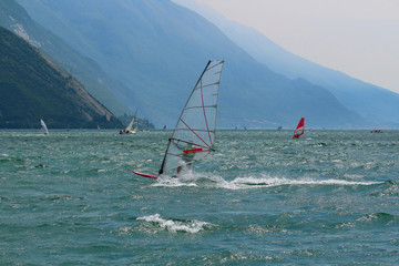 Windsurfer wearing required safety vest at Lake Garda glistening in the sun (Torbole, Italy)