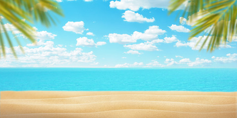 Summer beach with palm leaves. Sand, sea and blue sky with clouds. Copy space in the middle for promo text or logo. Summer travel concept.