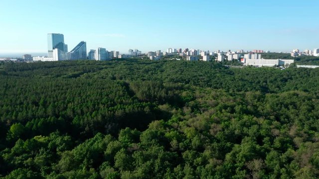  Green city in Russia.Camera flies over the forest and approach buildings in the dormitory area. Part 2