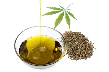A stream of flowing hempseed oil, marijuana leaf and hemp seeds.