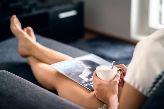 Sunday Morning With Magazine And Coffee. Happy Millennial Woman Relaxing With Fashion And Beauty Trends News And Cup Of Tea. Lady Enjoying Day Off And Me Time On Comfy Couch. Fun Weekend Freetime.