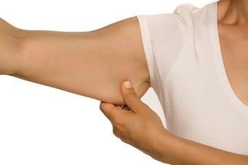 Woman pinching a fat on her arm on white background