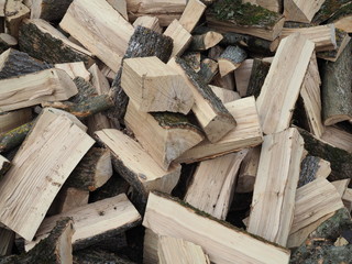 Isolated view on chopped wood. Piled in an unsorted way, looking quite chaotic. Ready to be set on fire.