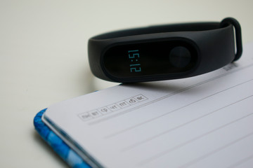 Smart watch on the background of a blue notebook, diary. Blue notebook, time, smart electronics, technology, communications, health, fitness bracelet.