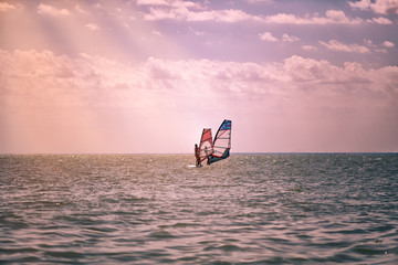 Romance in the sea couple man and woman together sailing on a windsurfing board while on vacation in south