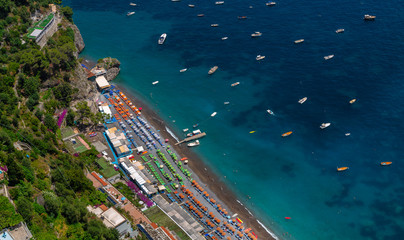 Aerial View of Positano Beach. Beautiful cliff view of Positano beach at daytime, with its beach umbrellas. Amalfi coast situated in province of Salerno, in the region of Campania, Italy.