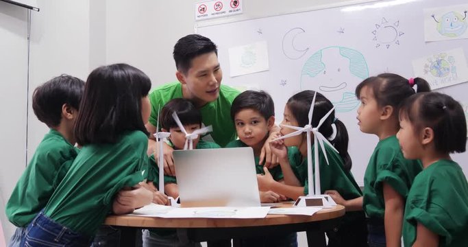 Teacher explaining to student in classroom about ecology project. Technology and Education concept.