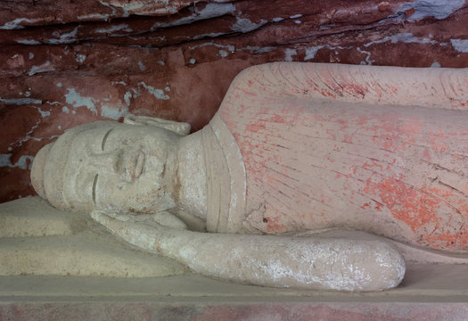 Clay sculpture of Sakyamuni in Nirvana or Sleeping Buddha in Grotto 16 carved in Northern Wei Dynasty in Bingling Temple and Grottoes, Yongjing, Gansu, China. UNESCO World Heritage.