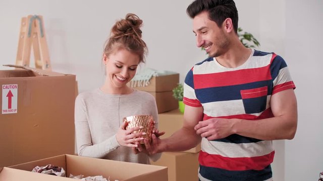 Loving couple packing stuff to cartons