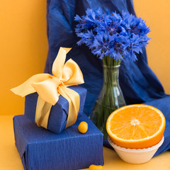Beautiful blue wildflowers - cornflowers, a box of jewelry as a gift, oranges. Summer greeting card with a holiday. Blue.