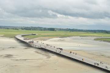 panorama de la baie avec prés salés, ciel nuageux et passerelle