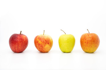 Four apples in a row with three red apples and one green apple