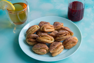 Biscuits with cottage cheese, tea with lemon and raspberry jam