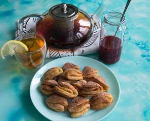 Biscuits with cottage cheese, tea with lemon and raspberry jam