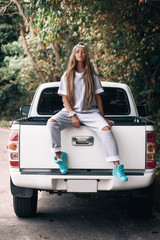 Young caucasian woman long hair wear white  hipster clothes,sit on pickup truck in countryside Thailand © Detkov D