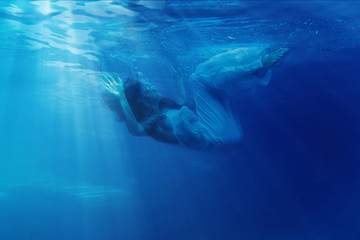 Fototapeta na wymiar Underwater woman portrait with white dress into the sea.