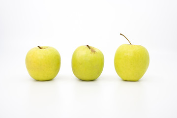 Three green apples in a row on a white background