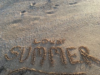 Fototapeta premium Summer - word summer wrote on the sand sunset beach