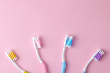 Oral hygiene. Multi-colored toothbrush on a bright pink background. top view. space for text