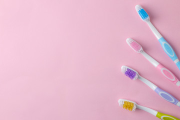 Oral hygiene. Multi-colored toothbrush on a bright pink background. top view. space for text