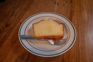Slices of delicious butter cake or pound cake on white plate put on wood table with copy space for background or wallpaper.