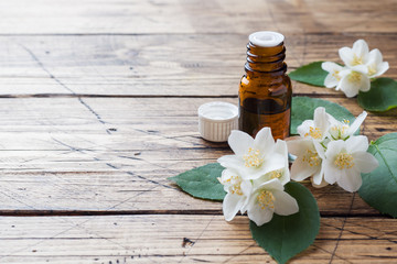 Oil of jasmine. Aromatherapy with jasmine oil. Jasmine flowers. Wooden background with copy space.