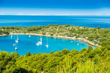 Obraz premium Panoramic view on Kosirina beach bay on Murter island in Croatia, anchored sailing boats and yachts on blue sea