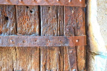 part of antique wooden doors with rusty metal slats close-up