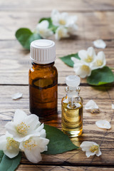 Oil of jasmine. Aromatherapy with jasmine oil. Jasmine flowers. Wooden background with copy space.