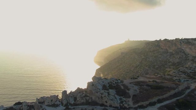 Dingli Cliffs in the sunset with dramatic sky, aerial drone dolly in shot revealing Dingli Aviation Radar, part of a triangulation arrangement, connecting Dingli Cliffs to Tas-Silġ and Wardija. Malta