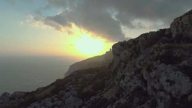 Dingli Cliffs in the sunset, aerial drone dolly in shot revealing Dingli Aviation Radar building, part of a triangulation arrangement, connecting Dingli Cliffs to Tas-Silġ and Wardija. Malta