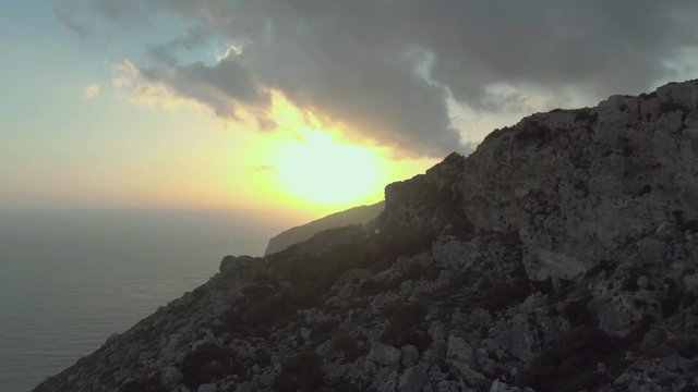 Dingli Cliffs in the sunset with dramatic sky, aerial drone dolly in shot revealing Dingli Aviation Radar, part of a triangulation arrangement, connecting Dingli Cliffs to Tas-Silġ and Wardija. Malta