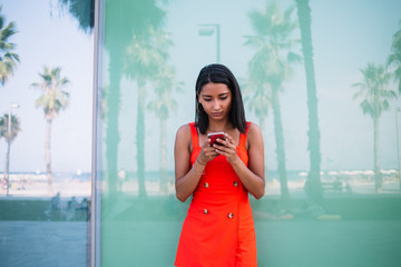 Young hipster tourist dressed in casual sundress checking information on website for travellers...