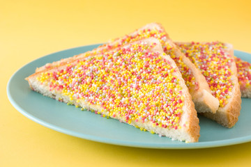 Traditional Australian fairy bread on yellow background. Close up