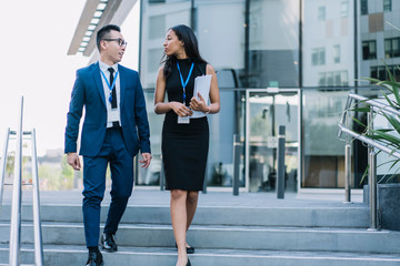 Stylish business people walking on street and talking