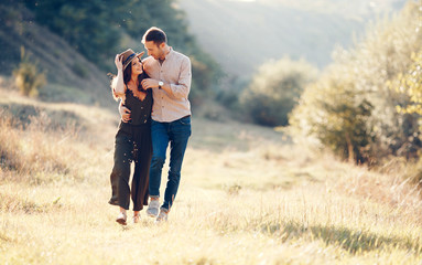 Couple in love having romantic tender moments at sunset on the park . Love, holidays and travel concept - Soft focus on them. Place the text.