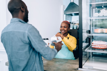 Obraz premium Black barista giving purchases to customer