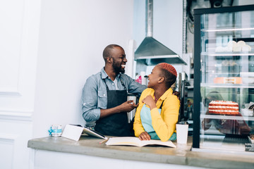 Black bartenders laughing behind counter