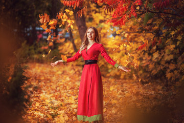 beautiful woman in autumn in  red forest walks