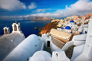 Santorini or Thira or Thera island, wide angle view of picturesque Oia village, hanging over the caldera. In the background, Thirasia island © Iraklis Milas